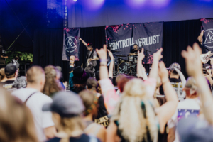 Kontrollverlust Auftritt der Band Kontrollverlust beim Elbenwald Festival, mit begeistertem Publikum. Die Musiker spielen auf der Bühne und erzeugen eine energiegeladene Atmosphäre, während Fans ihre Hände in die Luft heben und die Musik genießen.
