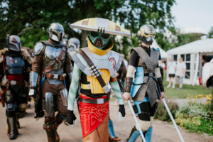 501st Legion Cosplayer in detaillierten Kostümen, inspiriert von Science-Fiction und Fantasy, beim Elbenwald Festival. Die Gruppe zeigt eine Vielzahl von Charakteren, während sie durch das Festivalgelände spaziert, umgeben von grüner Natur und Festivalatmosphäre.