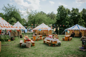 Hobbingen Bunte Zelte und rustikale Holzbänke prägen die Atmosphäre des Elbenwald Festivals. Der grüne Veranstaltungsort ist mit festlichen Fahnen und Laternen geschmückt und lädt Besucher zu einem kreativen Erlebnis voller Musik und Gemeinschaft ein.