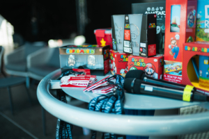 Mario Kart Turnier-Finale Tisch mit Merchandise und Preisen beim Elbenwald Festival 2023, darunter Super Mario Spielzeuge, Mikrofons und Ausweise für das Super Mario Turnier. Ideal für Fans von Gaming und Popkultur.